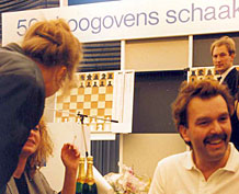 Schaakmeester Hans Böhm op het Hoogovens schaaktoernooi met DJ René Lust in de achtergrond